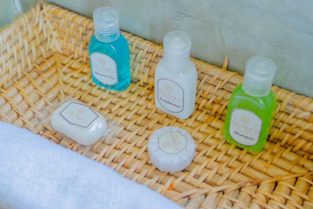 A neatly arranged wicker tray with hotel toiletries including shampoo, conditioner, shower gel, and soaps. A clean, welcoming detail often found in quality hospitality setups.